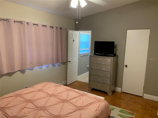 tiled bedroom featuring lofted ceiling and baseboards