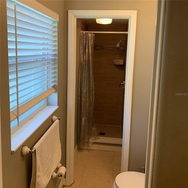 bathroom featuring tile patterned flooring, a stall shower, and toilet