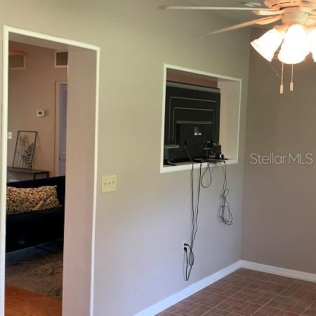 interior space featuring visible vents, baseboards, and ceiling fan