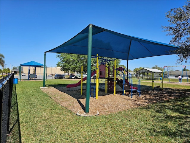 community jungle gym featuring a lawn