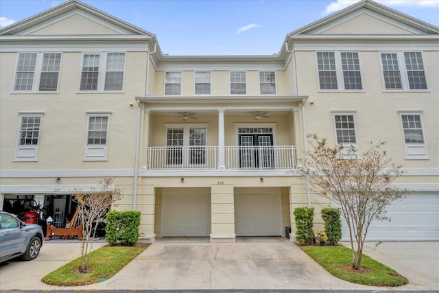 view of front of house featuring ceiling fan, driveway, an attached garage, and stucco siding