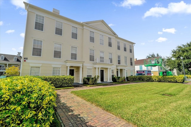 view of front of house featuring a chimney and a front yard