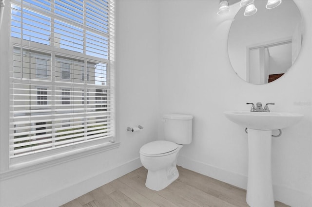 bathroom featuring wood finished floors, toilet, and baseboards