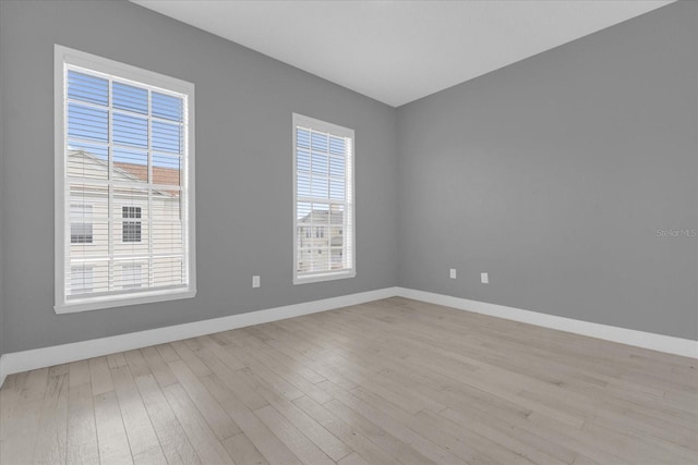 unfurnished room with baseboards and wood finished floors