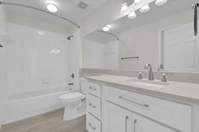 full bath featuring visible vents, toilet, tub / shower combination, vanity, and wood finished floors