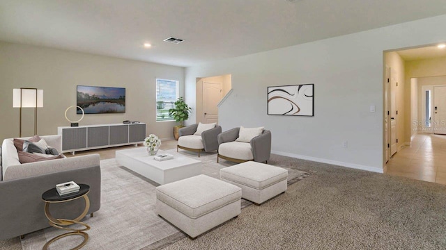 living room featuring light carpet, recessed lighting, visible vents, and baseboards