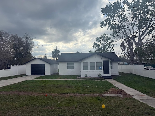 view of front of house featuring a garage, an outdoor structure, driveway, and fence