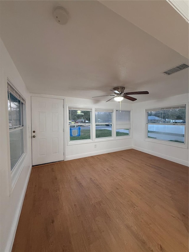 unfurnished sunroom with visible vents and ceiling fan