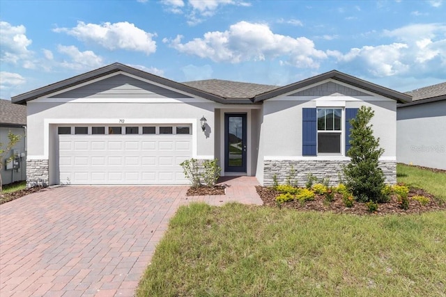 ranch-style home with a garage, stone siding, decorative driveway, and stucco siding