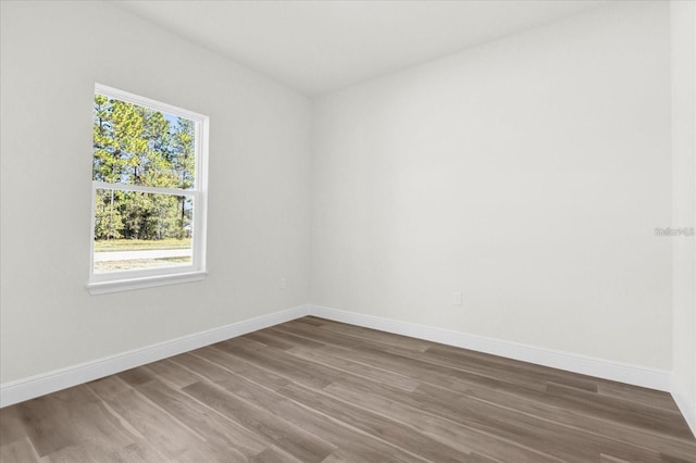 unfurnished room featuring baseboards and wood finished floors