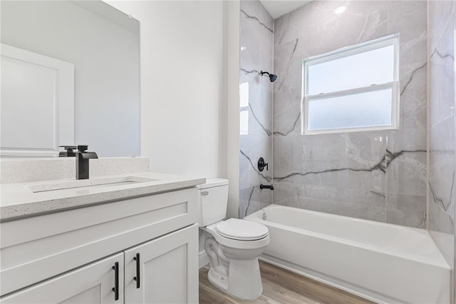 bathroom with toilet, washtub / shower combination, wood finished floors, and vanity