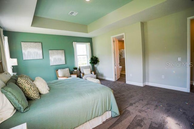 bedroom featuring baseboards, visible vents, a tray ceiling, and dark carpet