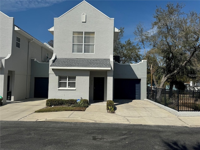 view of front of home with driveway, a garage, roof with shingles, fence, and stucco siding