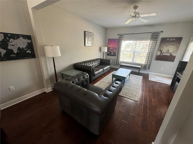 living room featuring ceiling fan, a textured ceiling, baseboards, and wood finished floors