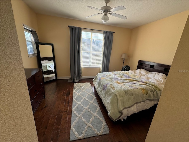 bedroom featuring dark wood-style floors, baseboards, a ceiling fan, and a textured ceiling