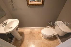 bathroom featuring toilet and baseboards