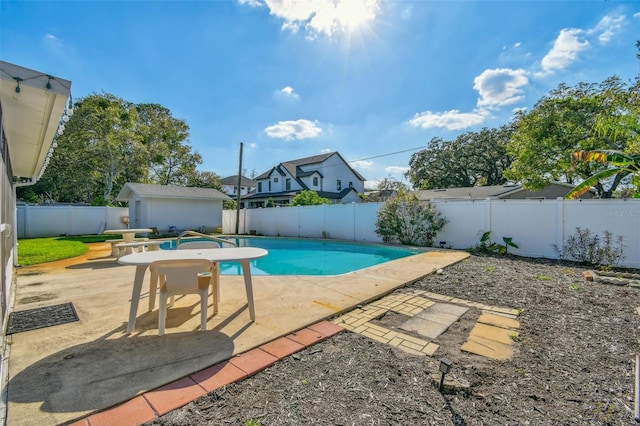 view of pool with a fenced backyard, an outbuilding, a fenced in pool, and a patio