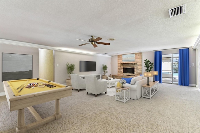 living area with light colored carpet, visible vents, a large fireplace, ceiling fan, and a textured ceiling