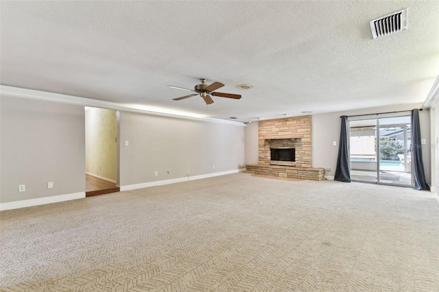 unfurnished living room with carpet floors, visible vents, a ceiling fan, a stone fireplace, and a textured ceiling