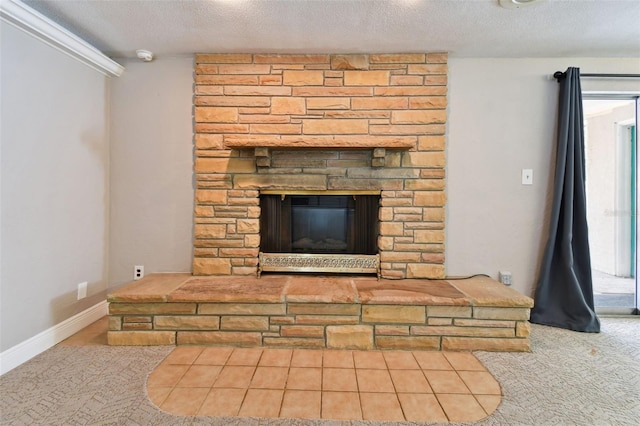 interior details with a textured ceiling, a stone fireplace, carpet flooring, and baseboards