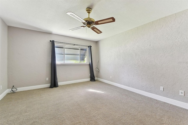 unfurnished room featuring ceiling fan, a textured wall, a textured ceiling, baseboards, and carpet