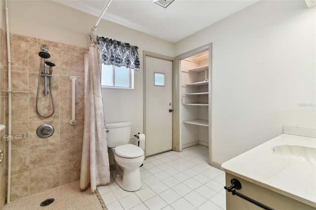 full bath featuring toilet, tile patterned flooring, a tile shower, and vanity