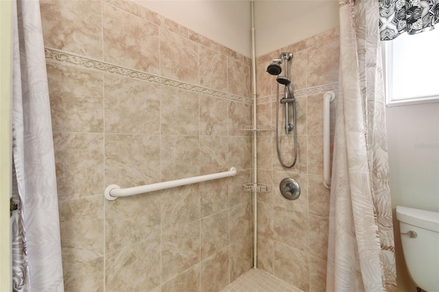 full bathroom featuring toilet and a tile shower