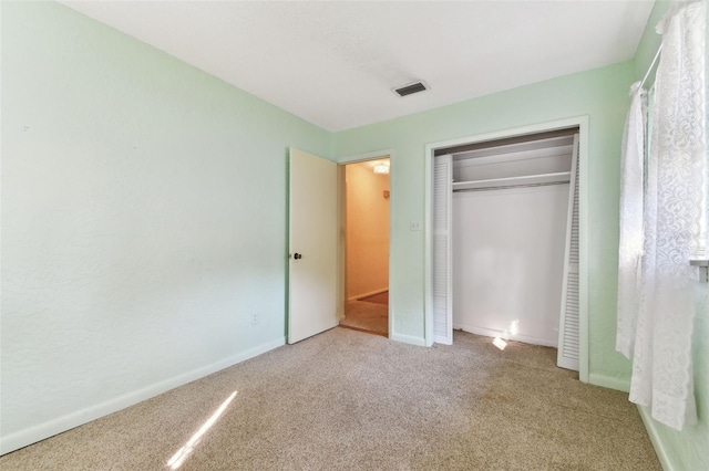 unfurnished bedroom featuring carpet, a closet, visible vents, and baseboards