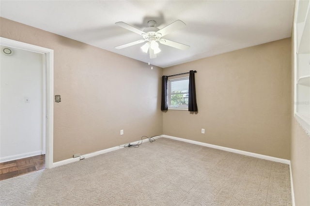 empty room with ceiling fan and baseboards