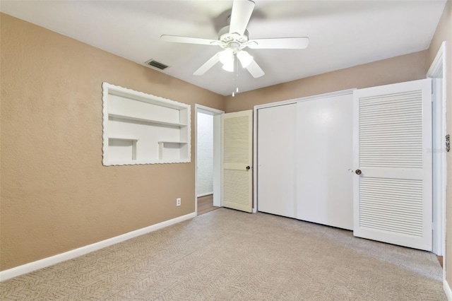 unfurnished bedroom with carpet, a closet, visible vents, a ceiling fan, and baseboards