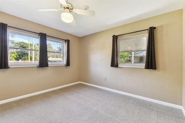 empty room featuring carpet flooring, a ceiling fan, and baseboards