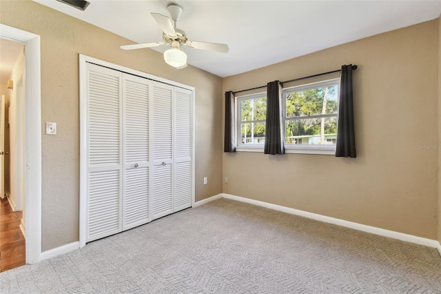 unfurnished bedroom featuring a closet, carpet flooring, a ceiling fan, and baseboards