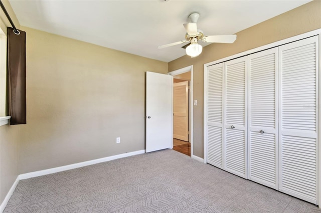 unfurnished bedroom with ceiling fan, carpet floors, a closet, and baseboards