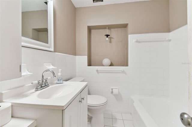 bathroom with toilet, a wainscoted wall, tile patterned floors, vanity, and tile walls