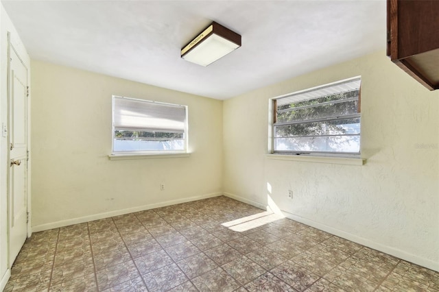 unfurnished bedroom featuring multiple windows, baseboards, and tile patterned floors