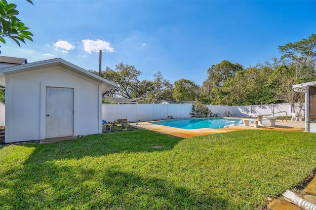 view of yard featuring a fenced in pool, a patio, a fenced backyard, a storage unit, and an outdoor structure