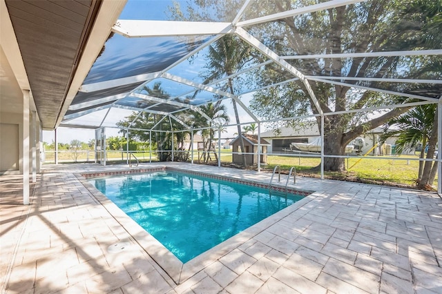 outdoor pool with a lawn, a patio area, and a lanai