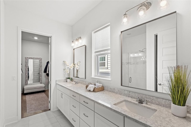 bathroom with double vanity, a stall shower, tile patterned flooring, and a sink