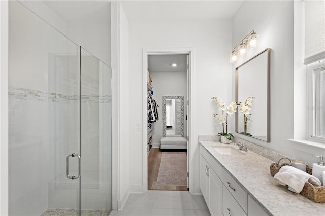 full bath with baseboards, a shower stall, vanity, and tile patterned floors