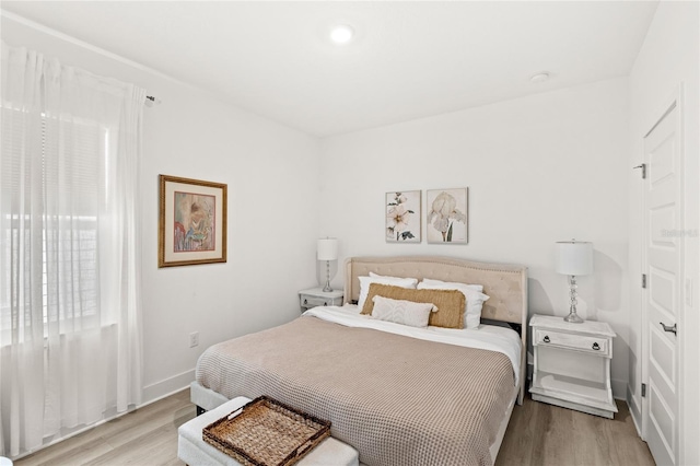 bedroom with light wood-style floors and baseboards