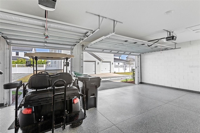 garage featuring concrete block wall and a garage door opener