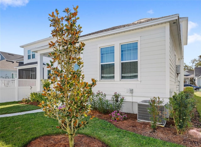 view of front of property with a front yard, fence, and central AC unit