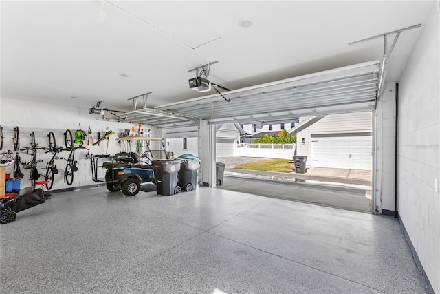 garage with a garage door opener and concrete block wall