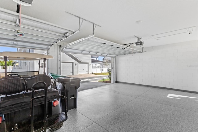 garage with a garage door opener and concrete block wall