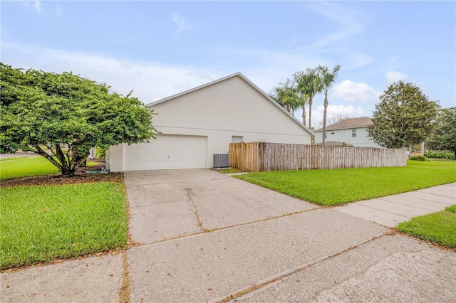 view of property exterior with a yard, central air condition unit, stucco siding, fence, and a garage
