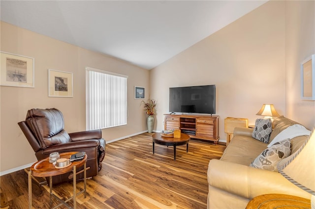 living room with lofted ceiling, baseboards, and wood finished floors