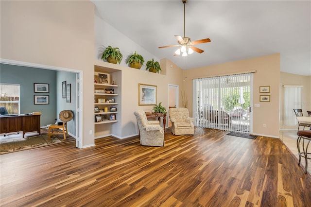 sitting room featuring built in features, a ceiling fan, wood finished floors, high vaulted ceiling, and baseboards