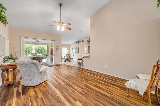 sitting room featuring lofted ceiling, ceiling fan, wood finished floors, and baseboards
