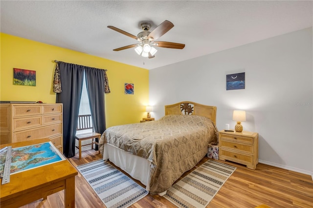 bedroom featuring light wood-style floors, baseboards, and a ceiling fan