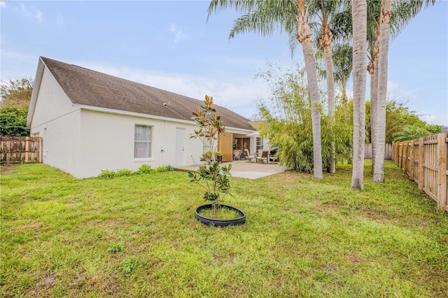 back of property featuring a lawn, a patio area, a fenced backyard, and stucco siding